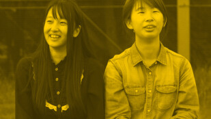 Czarno-żółte zdjęcie: Dziewczyna i chłopak uśmiechają się. Są Azjatami. Dziewczyna patrzy w lewą stronę, ma długie, ciemne włosy. Chłopak po prawej ma krótkie włosy. Jest ubrany w dżinsową koszulę.