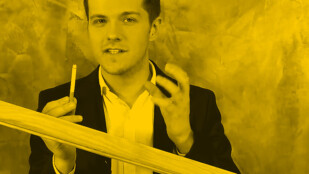 Czarno-żółte zdjęcie. Radek Kotarski patrzy obiektyw i unosi ręce na wysokość ramion. W lewej ręce trzyma papierosa. Na pierwszym planie drewniana belka.